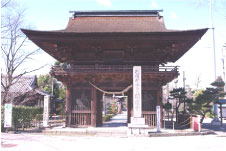 青空の下に建つ赤茶色色の屋根の円鏡寺楼門の写真