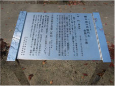 屋外に設置された細かい文字が刻まれた銀色の説明板の写真