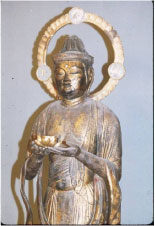 両手を差し出した仏像を右上面から撮影した写真