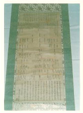 細かい文字がたくさん書かれている緑色の掛け軸を撮影した写真