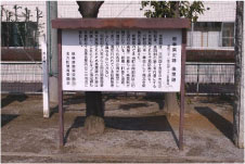 茶色い枠組みに茶色い屋根がついている文字の書かれた説明板を正面から撮影した写真
