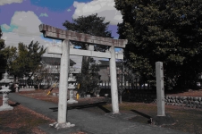 朝日神社の白い正面鳥居を標柱と一緒に参道の左斜め前から撮影した写真