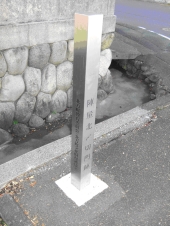 北〆切門跡の曲がり角に灰色の標柱が設置されている写真