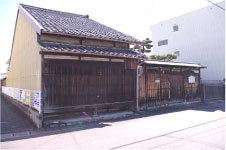 瓦屋根の平屋の年季の入った家と小さな門が設置された五竹坊居宅跡の写真