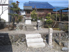 屋外にある白色の小さな2段の階段の上に小さな社が建っている写真