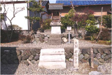 白い小さな2段の階段の手前に石柱と奥に建っている小さな社を正面から撮影した写真