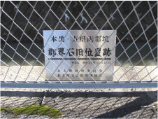 郡界石旧位置跡と書かれた看板がフェンスの奥に設置されている写真