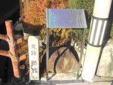 史跡郡界石と書かれた石柱と電柱との間にある郡界石とその上部に設置された説明板の写真