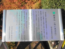 銀色の板に黒字の説明書きが書かれた郡界石の説明板の写真