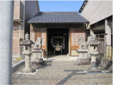蔵の中に収められている黒い漆塗りの神輿を屋外から撮影した写真