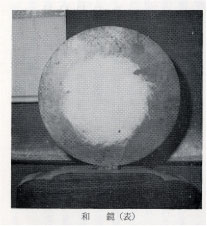台座に固定された真ん中が白くなっている様子の和鏡の昔の白黒の写真