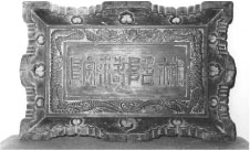 縁が波のように飾り彫りをされた木彫に旧字体の漢字四文字が彫られている様子の白黒の写真