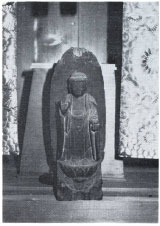 右手を前に出した木像を正面から撮影した白黒の写真