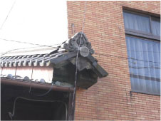 日本家屋とビルとの境目に残された江戸末期に作られた卯建の一部を左斜め前から撮影した写真