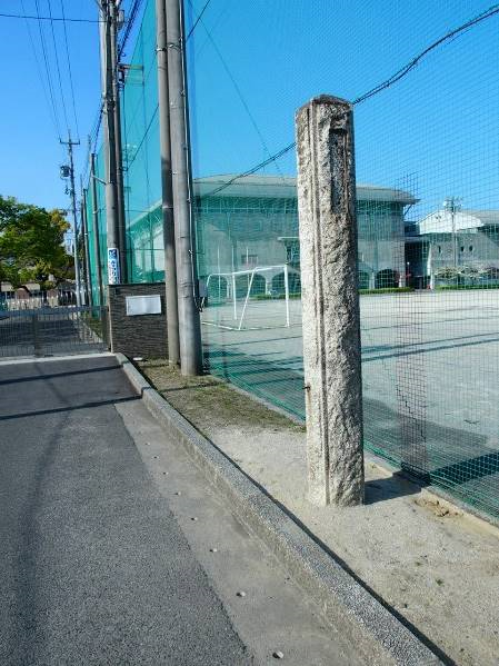 校庭と道路との境に建てられている石造りの門柱の写真