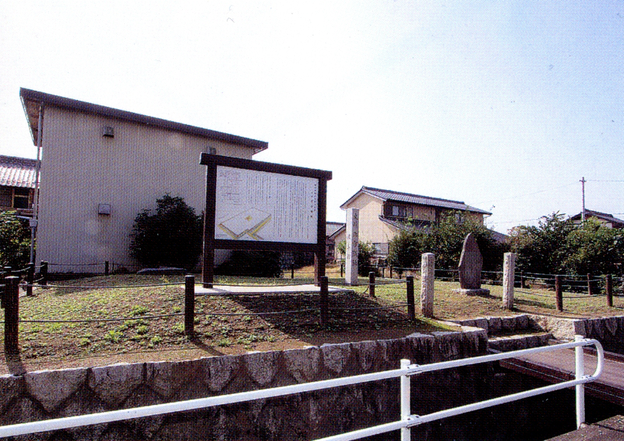 住宅街に囲まれた少し高くなった土地に白い解説の看板と、小判型の石が設置されている北方城跡の写真