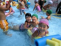 浮き輪に乗ってプールで遊んでいる園児たちの写真