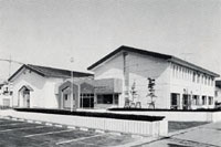 白い壁と褐色の屋根の北方町広域勤労青少年ホームの外観の写真