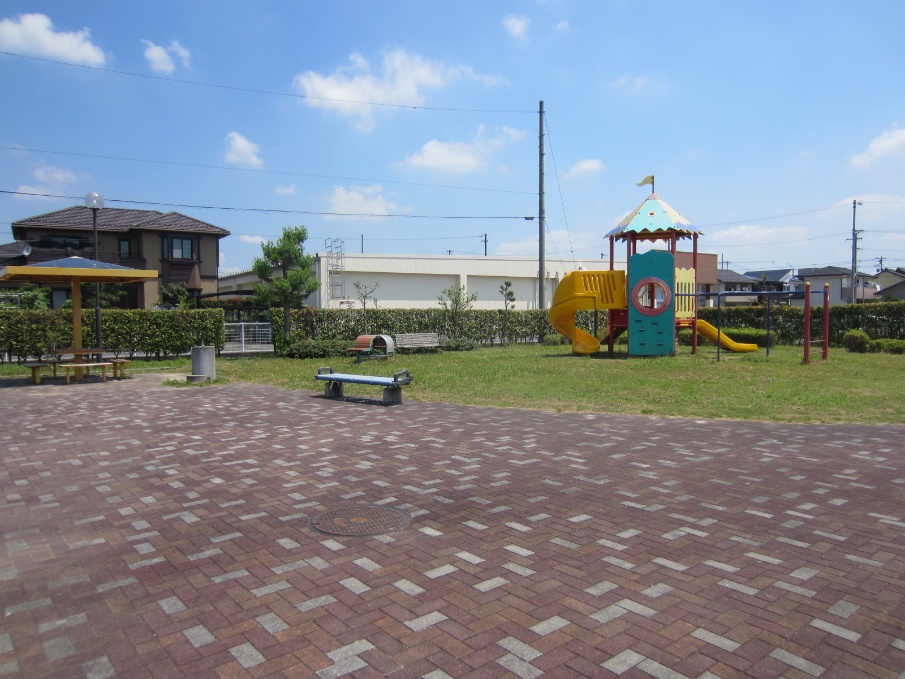 加茂公園敷地内東側の風景写真。写真中央に背伸ばしベンチ、右側にコンビネーション遊具が確認できる