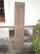 涅槃像図が収納されている箱の蓋を建物の白い壁に立てかけている写真