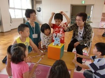 児童たちが地域の方とおもちゃを使って遊んでいる写真